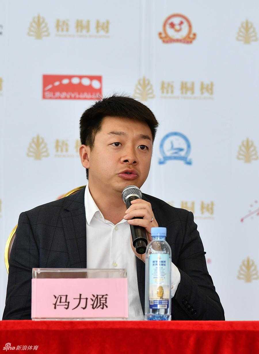 赛事总监冯力源与嘉宾共同查看赛事资料，表情认真专注，体现了赛事组织工作的严谨与专业。