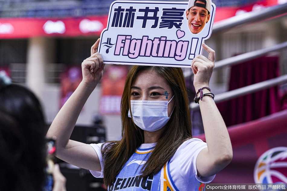 身穿白色应援服的林书豪美女粉丝团成员，露出灿烂笑容，她们手中举着定制的助威手举牌，成为看台上一道亮丽的风景线。