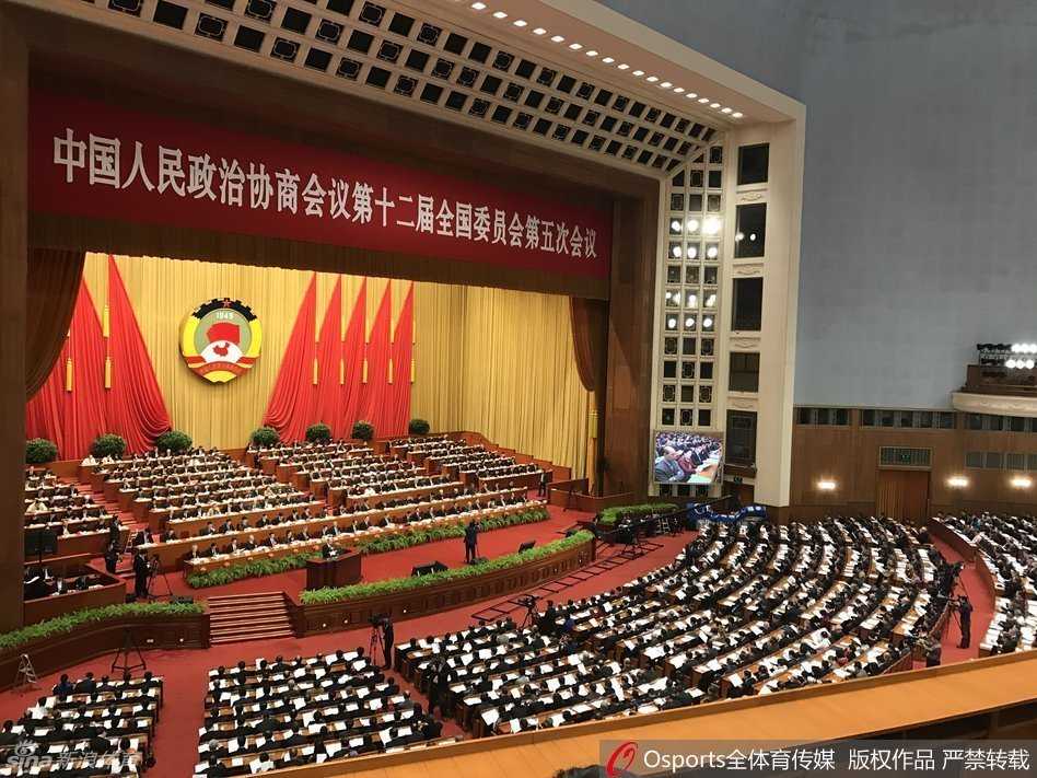 会议间隙，姚明与另一位委员亲切握手交流，两人面带微笑，目光直视对方，身后是庄重的会场环境，这简单的一握传递出委员间对议题的共鸣与相互支持。
