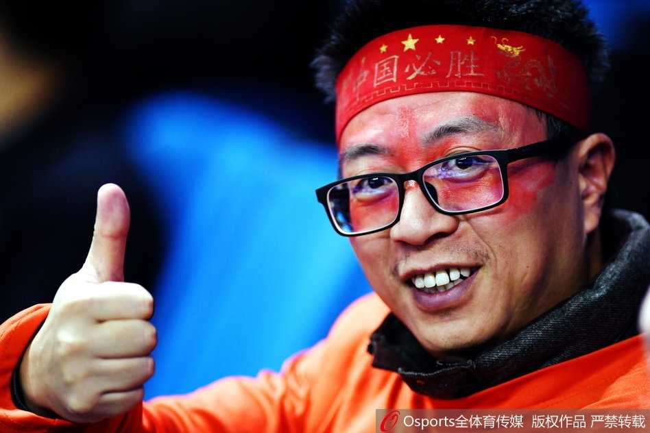 南京主场山呼海啸，看台被染成红色海洋，巨型国旗传递时球迷眼中闪烁着激动的泪光